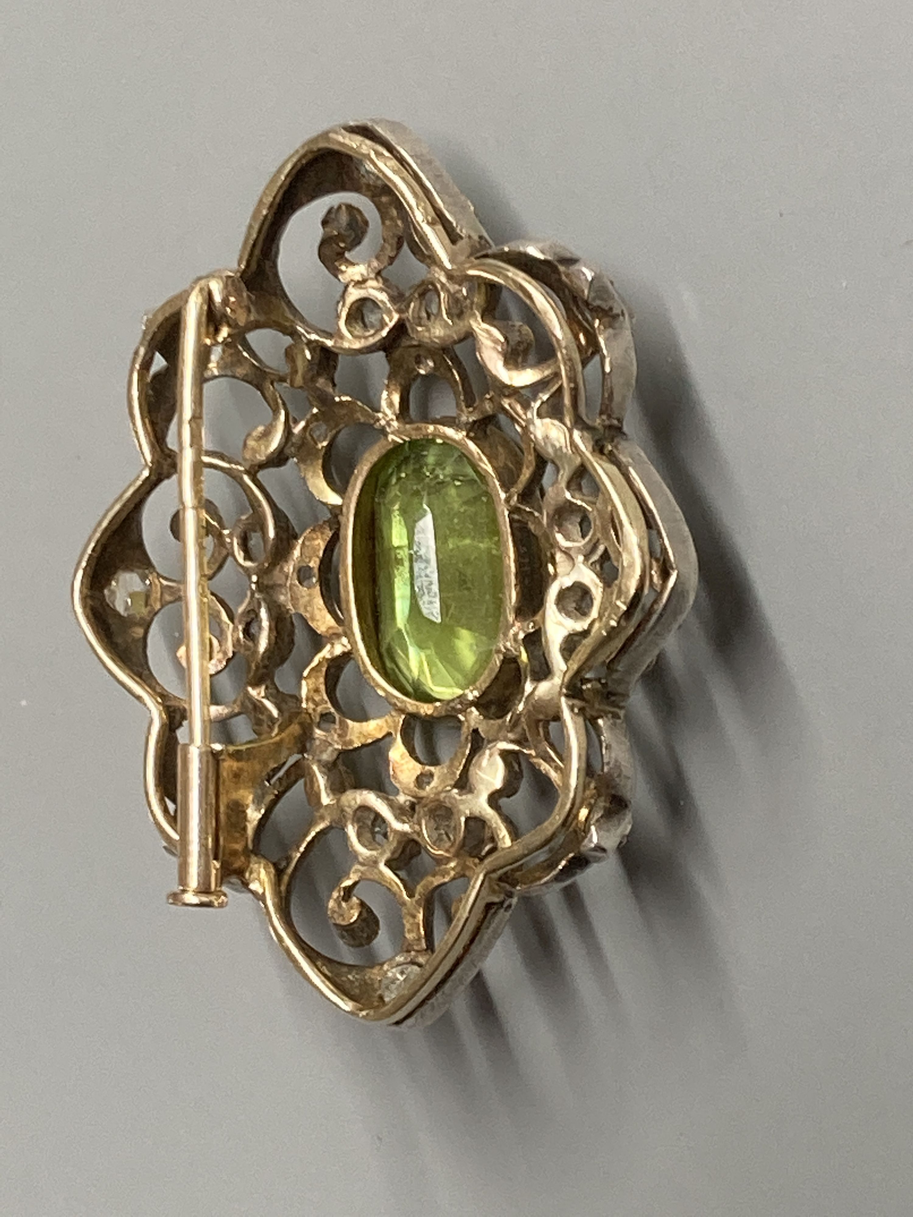 An early to mid 20th century Austro-Hungarian? white and yellow metal peridot and diamond set brooch, 38mm, gross 9 grams.